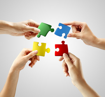 Puzzle-Teile werden in Teamarbeit zusammengesetzt