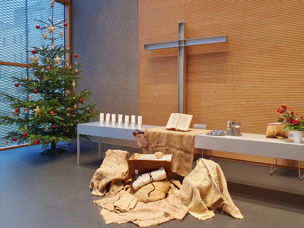 Christbaum, Dekoration für das Krippenspiel und Altar mit Abendmahlsgeschirr in der Ev. Johanneskirche Wiesbaden